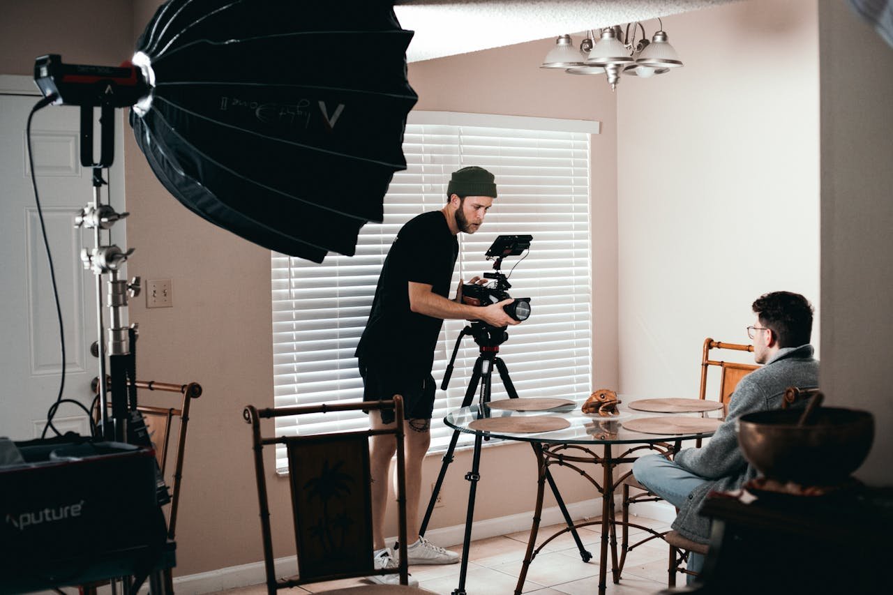 Cameraman setting up Canon camera indoors for video production filming scene.